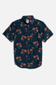 The Grant Slim Shirt / Wildflower by Bridge & Burn is a sustainable slim fit shirt with a dark blue base, orange floral pattern with green stems, short sleeves, collar, button-up front, and curved hem—ideal for summer style.