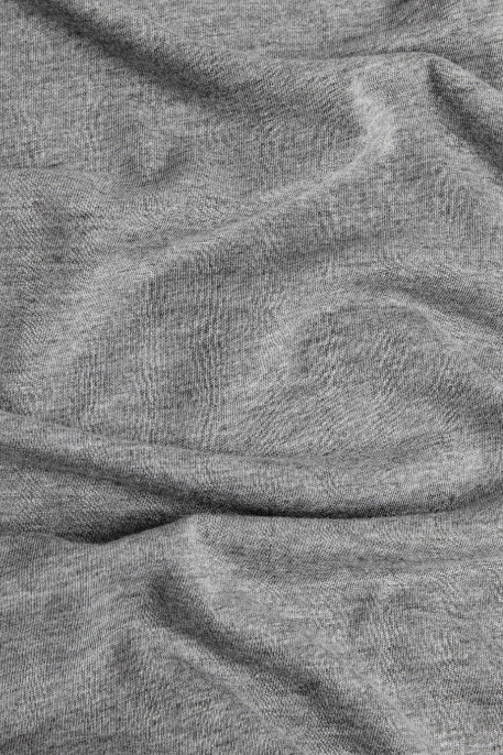 Close-up of the Men's Grown Tee in grey by Bridge & Burn, featuring a textured fabric made from recycled polyester with gentle folds, soft shadows, and a slightly wavy surface.