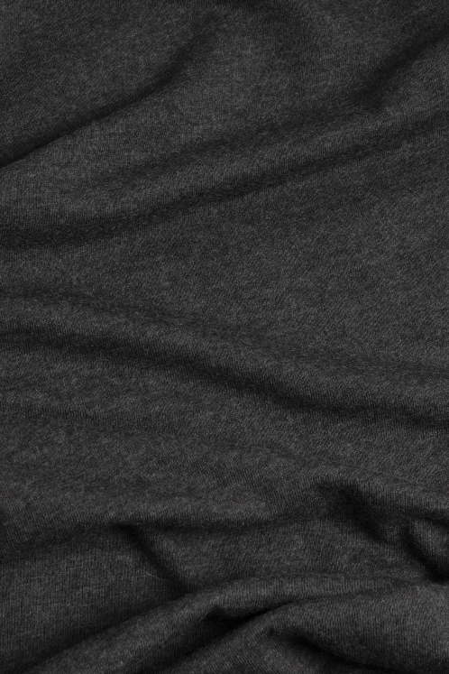 A close-up of the Bridge & Burn Women's Side Winder Tee in Black shows its soft recycled polyester fabric with subtle folds and a slightly heathered texture, creating gentle shadows and depth.
