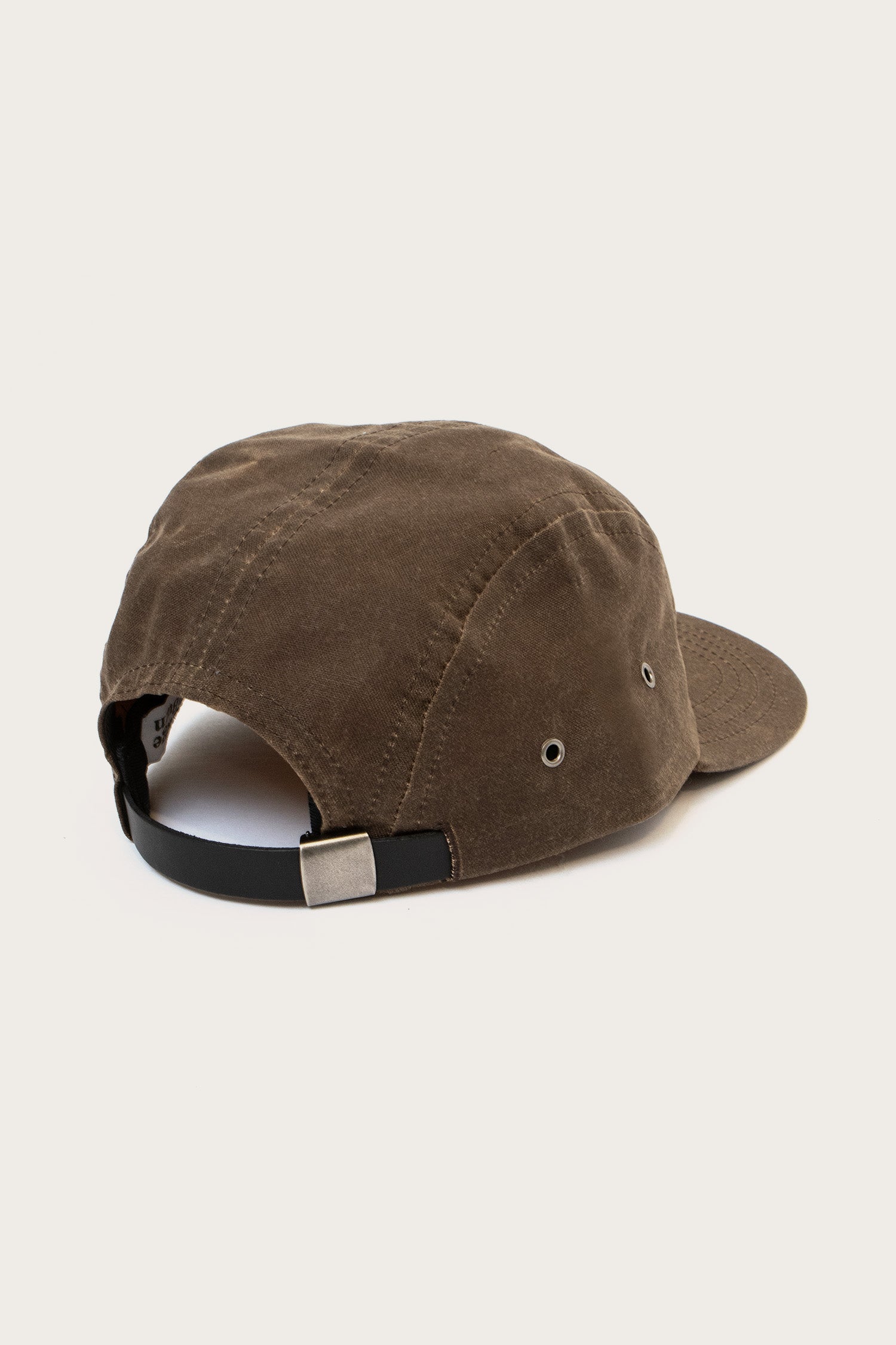The Bridge & Burn Camper Waxed 5 Panel Cap in Umber is shown from the back with a black adjustable strap, silver buckle, metal side eyelets, and a slightly curved brim against a plain white background.