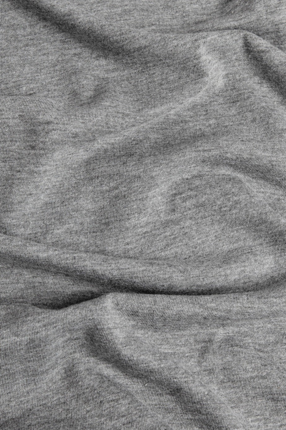 A close-up of light gray fabric with visible texture and soft folds, as seen on the Men's Bloom Tee in Grey by Bridge & Burn—perfect for a comfortable, lightweight organic cotton shirt.