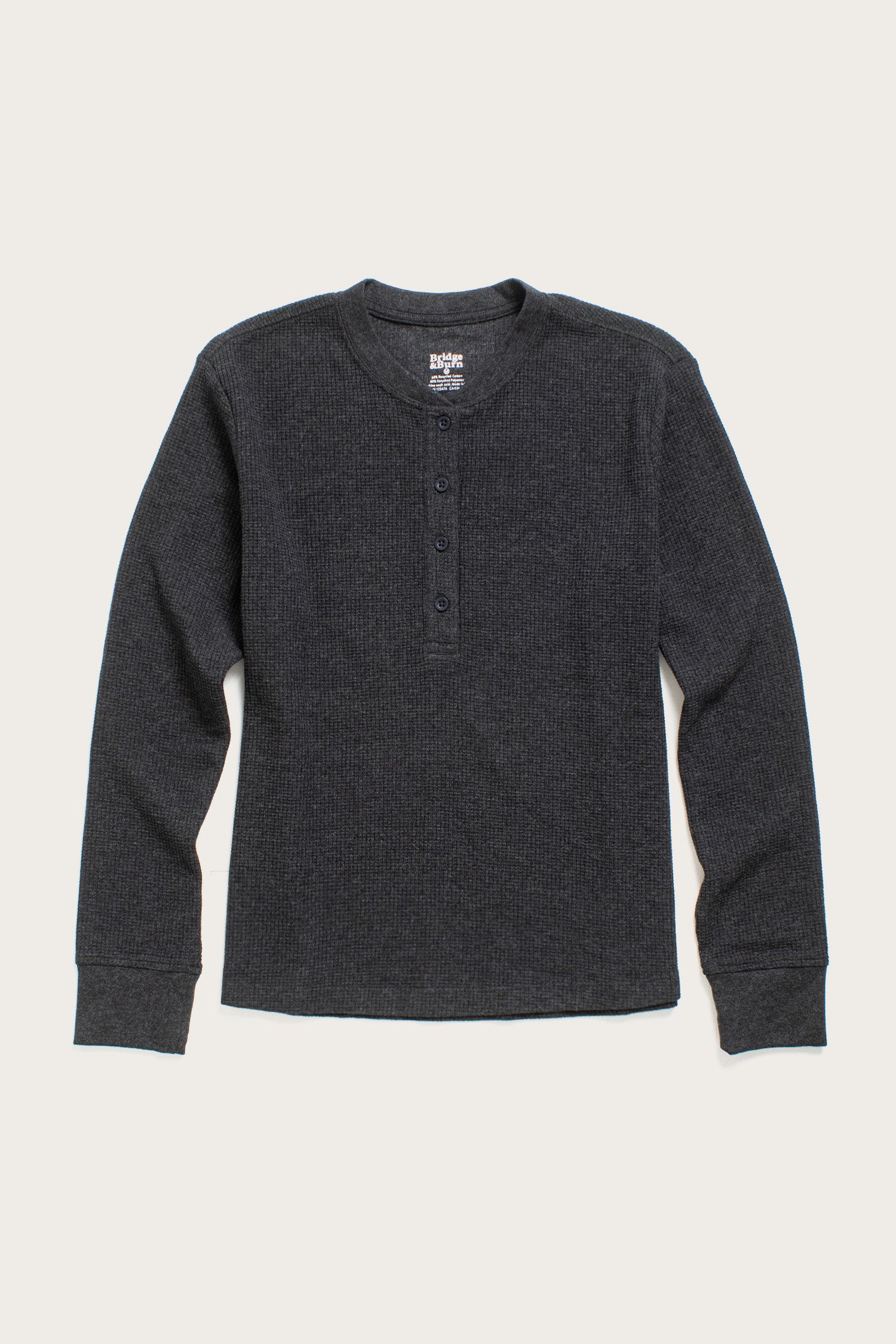 The Bridge & Burn Women's Recycled Waffle Henley in Charcoal Melange features a thermal waffle-knit texture, long sleeves, and a round neckline with a button placket, shown laid flat on a light background.