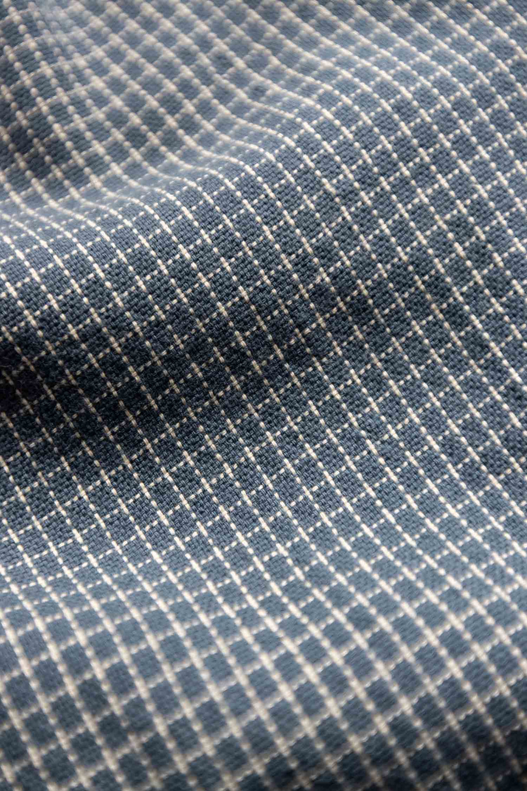 Close-up of the Lana Shirt / Navy Grid by Bridge & Burn: blue 100% cotton fabric with a small white grid pattern and subtle texture, ideal for a relaxed fit short sleeve button up.