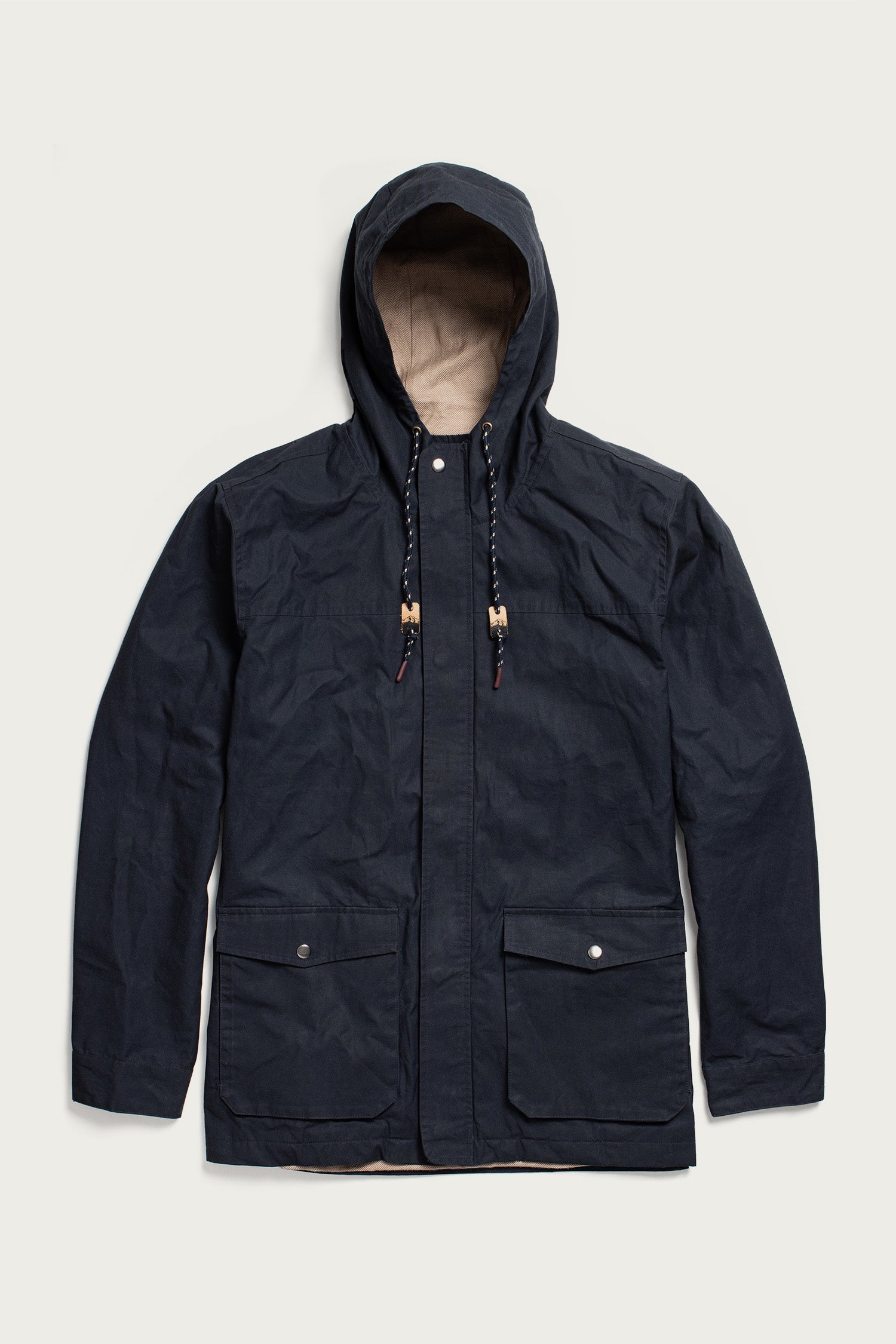 The Bridge & Burn Marshall Jacket in navy waxed canvas features a water-resistant shell, hood with drawstrings, front zipper and snap buttons, plus two large flap pockets—shown flat on a light background.