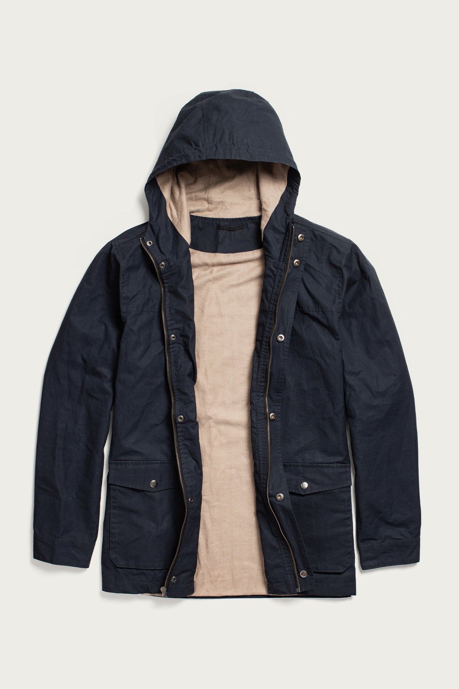 The Bridge & Burn Marshall Jacket in navy waxed canvas is shown laid flat and open, revealing a beige inner lining, snap buttons, and front flap pockets.