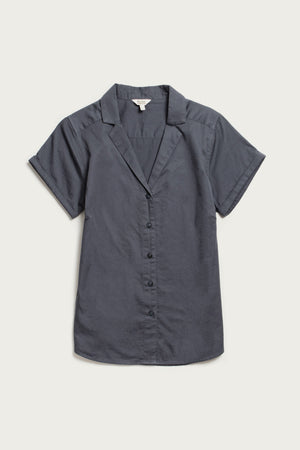 The Bridge & Burn Innes Shirt in light navy is a relaxed fit, short sleeve button-up crafted from organic cotton, featuring open lapels and a notched collar, shown laid flat on a white background.
