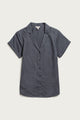 The Bridge & Burn Innes Shirt in light navy is a relaxed fit, short sleeve button-up crafted from organic cotton, featuring open lapels and a notched collar, shown laid flat on a white background.