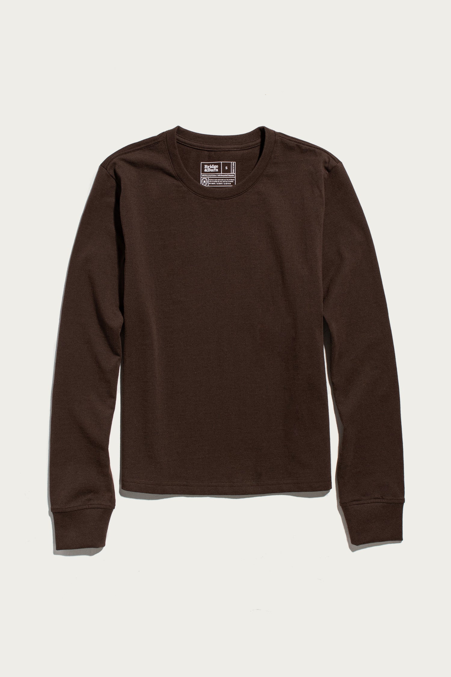 A Bridge & Burn Audrey Long Sleeve Tee in Truffle, featuring a relaxed fit and long sleeves, is laid flat on a white background. Made from recycled cotton, this crew neck shirt blends comfort and sustainability in an enduringly classic design.