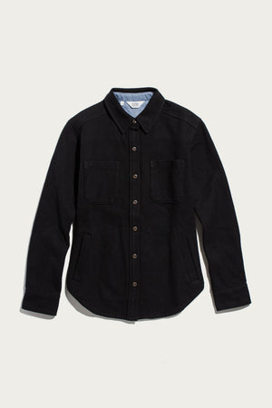 The Dawson Overshirt in Ink Stone by Bridge & Burn is a black button-up shirt jacket crafted from recycled cotton, featuring long sleeves, a collar, two chest pockets, and convenient side pockets. Shown against a plain white background, this modern recycled overshirt is perfect for those who value sustainable clothing.