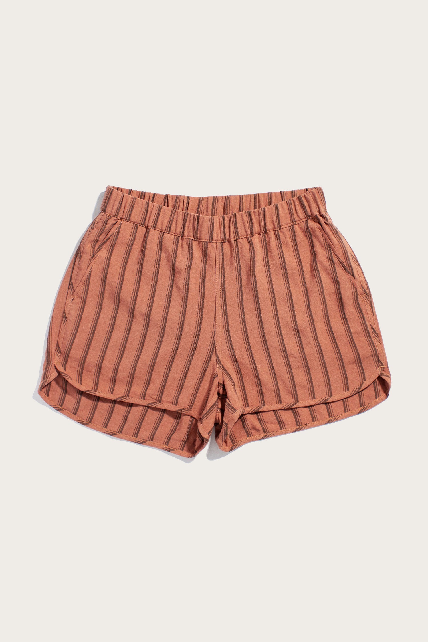 Bridge & Burn’s Luca Track Short in Rust Stripe features peach linen-viscose fabric with vertical brown stripes, an elastic waistband, and side pockets, shown against a plain white background.