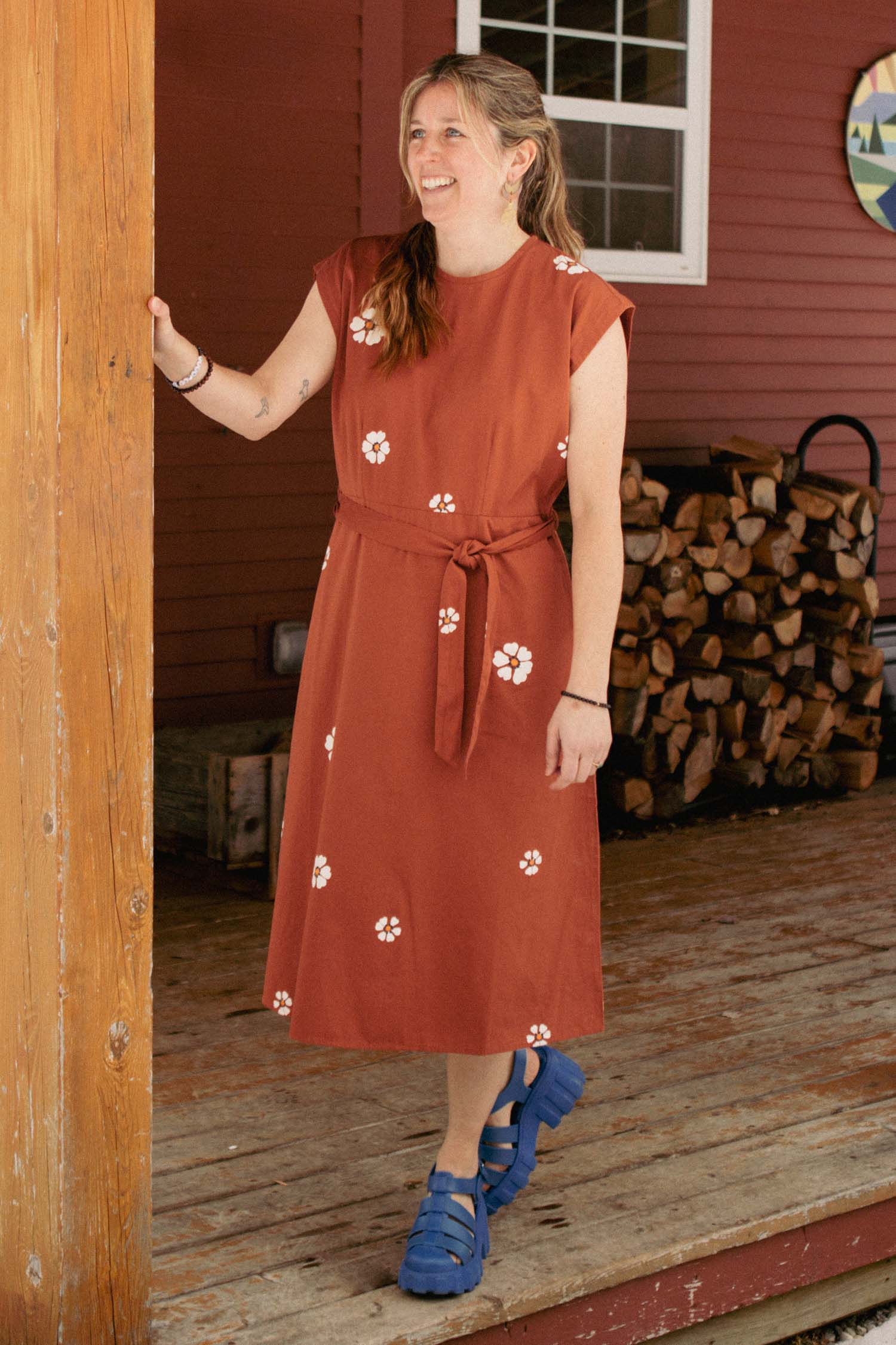 The Eloise Dress by Bridge & Burn in Redstone Bloom features an A-line silhouette, short sleeves, belted waist, white floral print, round neckline, back zipper, and knee-length cut—all in 100% cotton for essential everyday style.